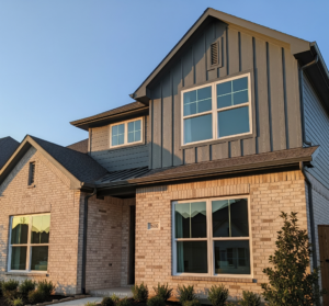 A modern Dallas-Fort Worth home with light brick and dark gray siding features prominent white vinyl windows by 1n20 Home Services